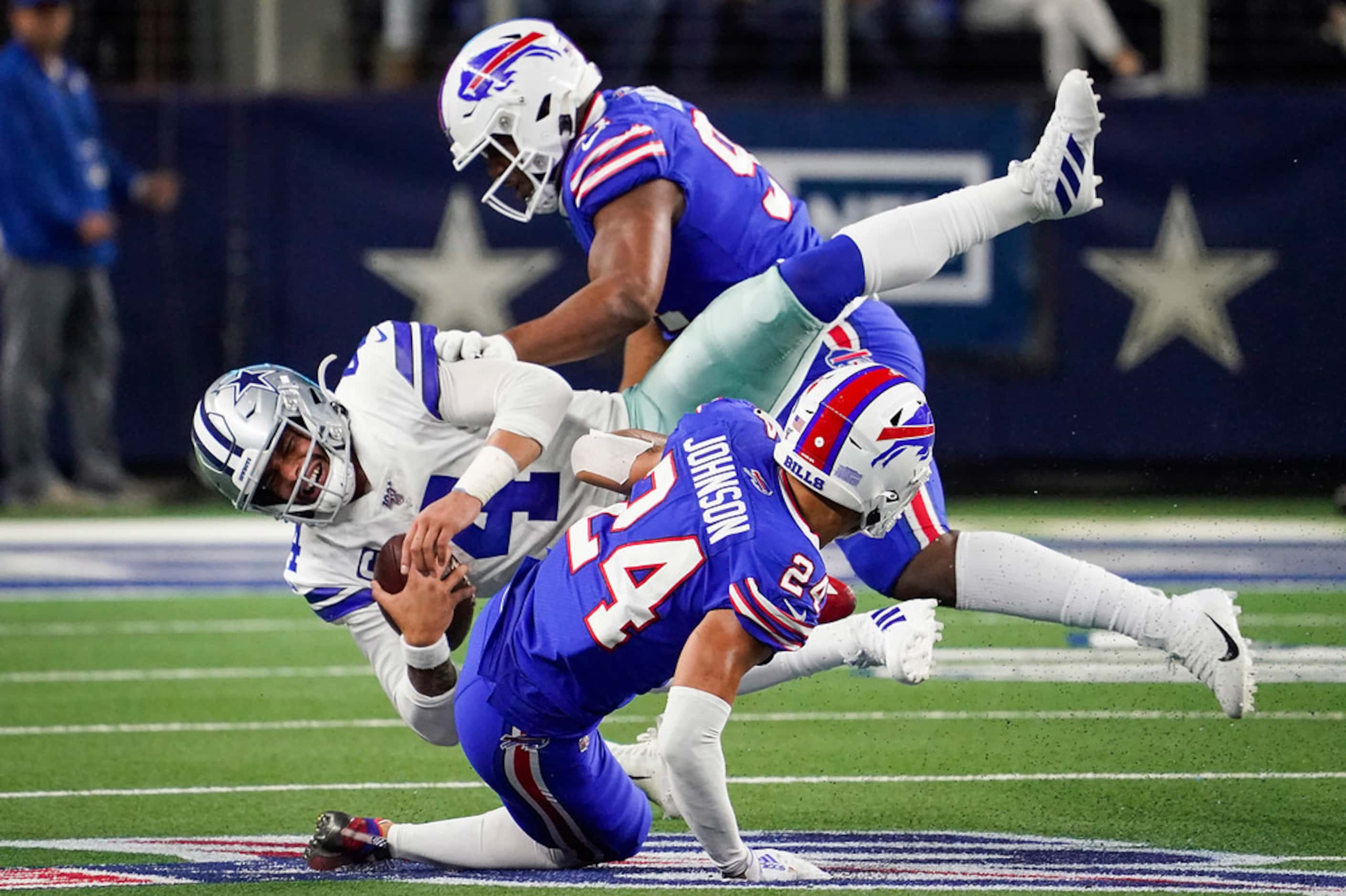 Dallas Cowboys quarterback Dak Prescott (4) is knocked off his feet by Buffalo Bills...