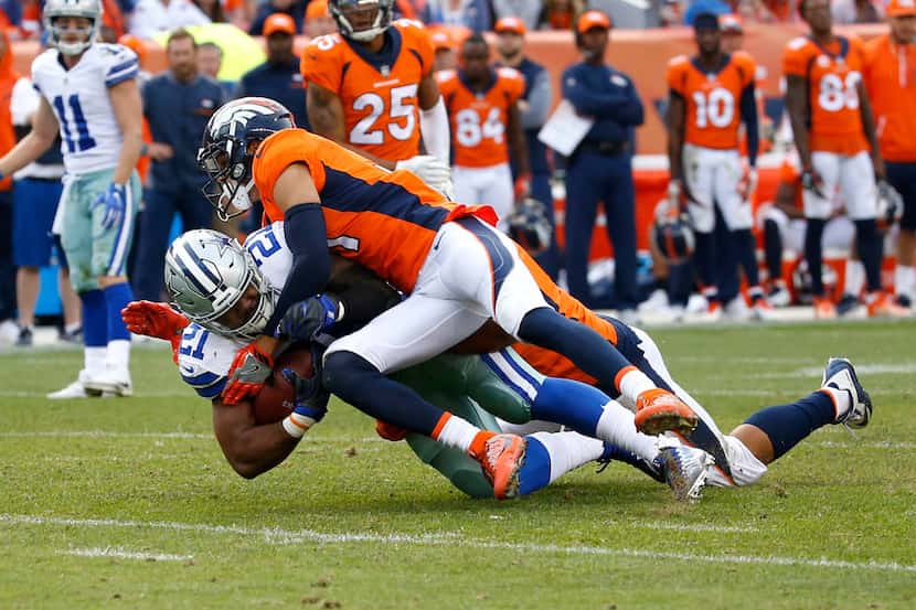 Dallas Cowboys running back Ezekiel Elliott (21) is tackled by Denver Broncos strong safety...