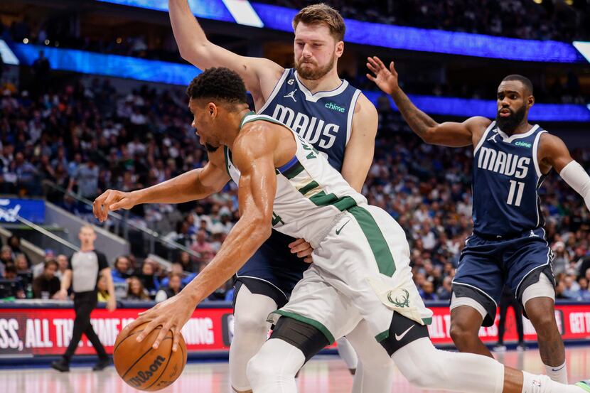 Dallas Mavericks guard Luka Doncic (77) defends against a driving Milwaukee Bucks forward...