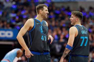 Mavericks forward Dirk Nowitzki (41) laughs with teammate Luka Doncic (77) during the first...