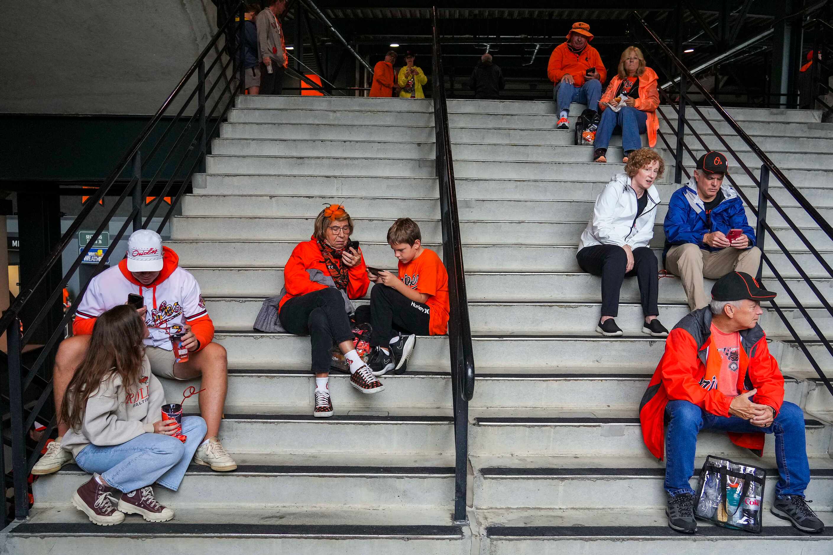 Fans sit in stairwells during a rain delay prior to Game 1 of an American League Divisional...