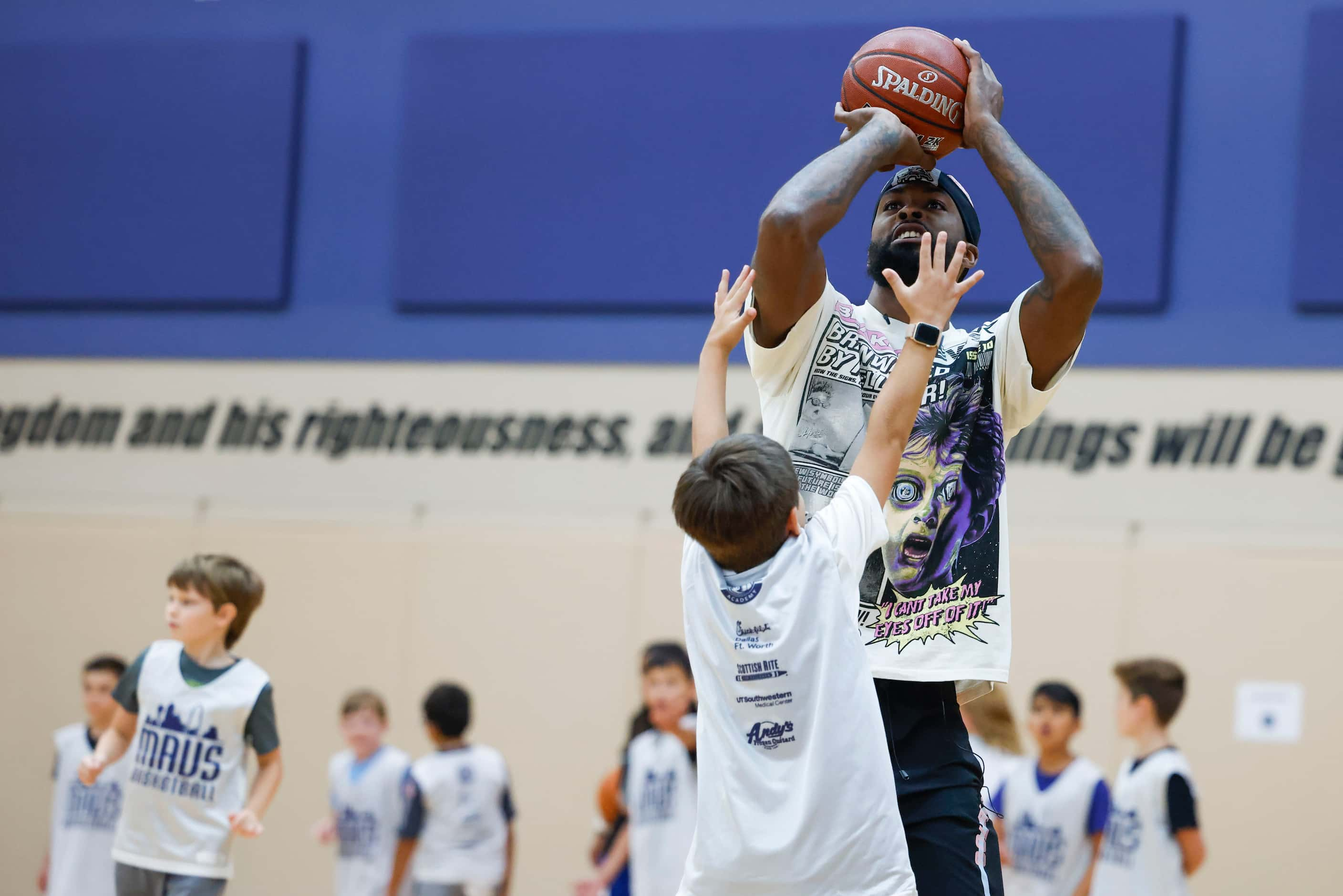 Dallas Mavericks’ Naji Marshall, play ball with young basketball campers during a Hoop Camp,...