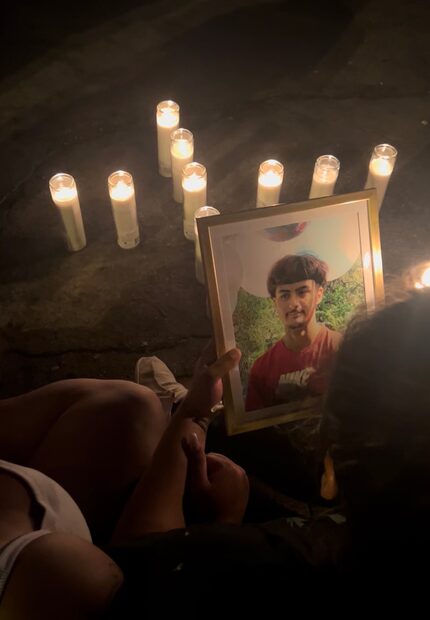 A loved one holds a portrait of Jordan at a vigil Saturday in Dallas.