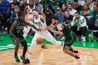 Dallas Mavericks guard Luka Doncic (77) loses the ball as Boston Celtics guard Jrue Holiday...