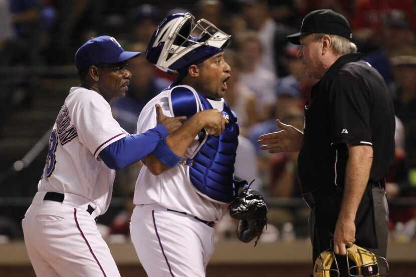 Texas Rangers catcher Bengie Molina and manager Ron Washington argue with home plate umpire...