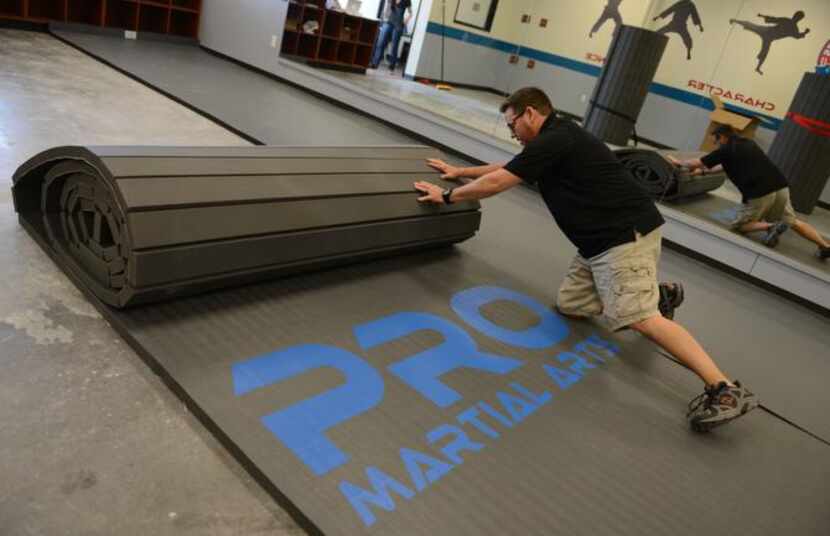 
Matthew Woody rolls out the mat in his new Pro Martial Arts gym in Frisco. The gym will...