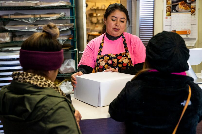 Naomi Vera Chavarria center, helps customers purchase a birthday cake at Vera's Bakery Inc....