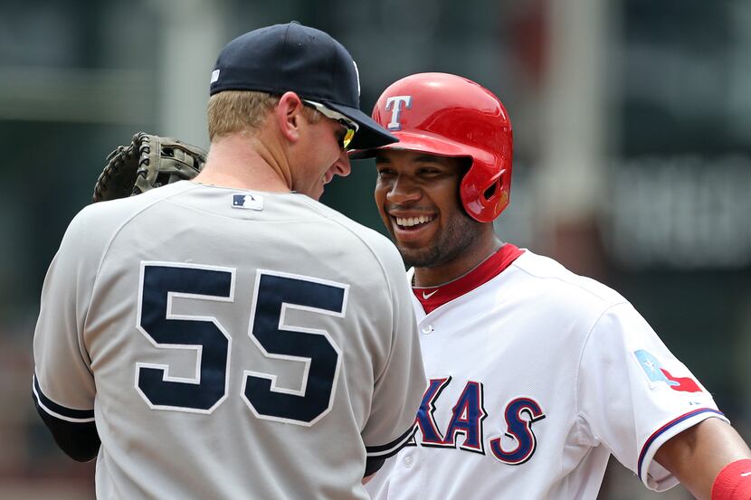 ARLINGTON, TX - JULY 25: Elvis Andrus #1 of the Texas Rangers shares a laugh with Lyle...
