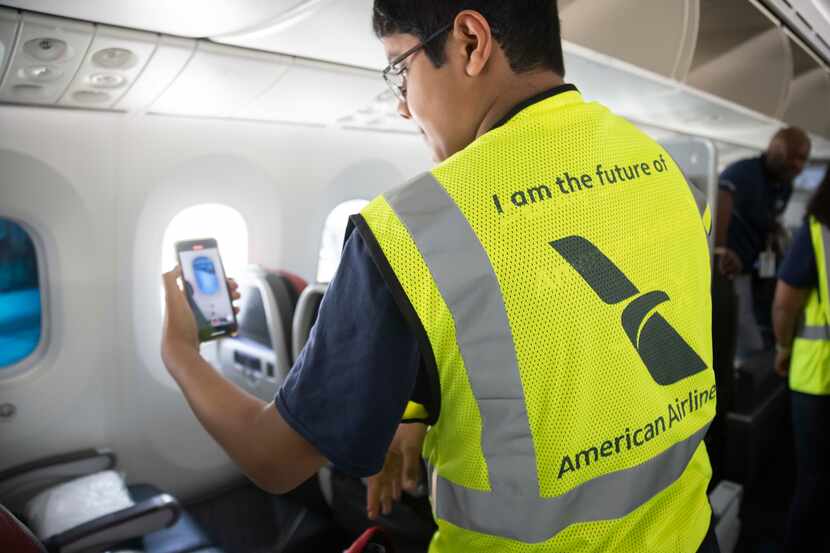 Varun Varshney, 16, of Austin looks at a window on an American Airlines 787 plane during the...