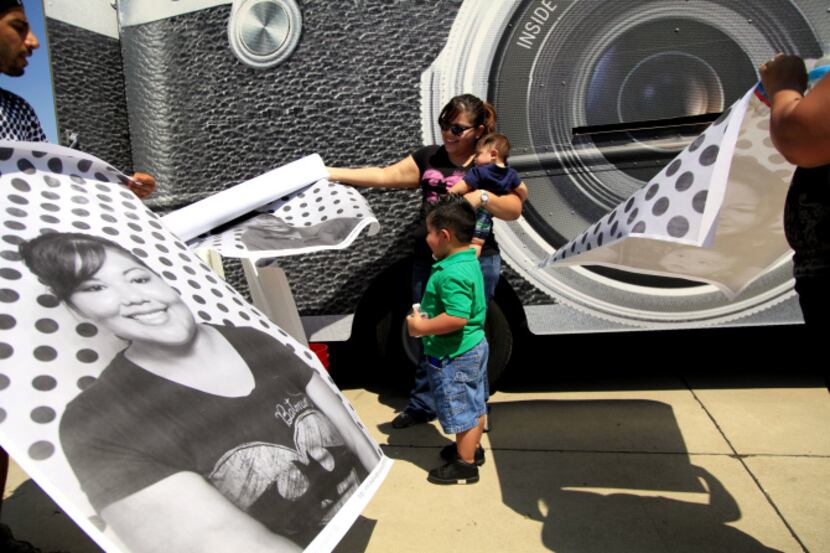 Babak Houshmasg (left) rolled up a photograph of Angela Vazquez (center) as she held Austin...