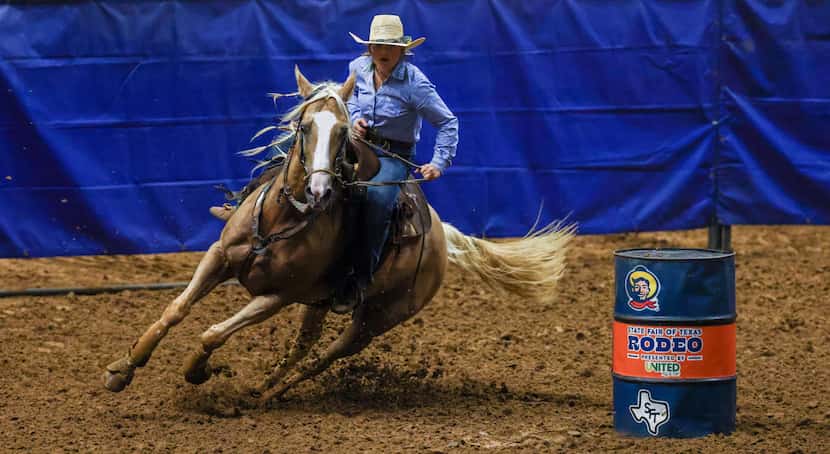 Andi Wilson rides around barrels while competing in the barrel racing event in the State...