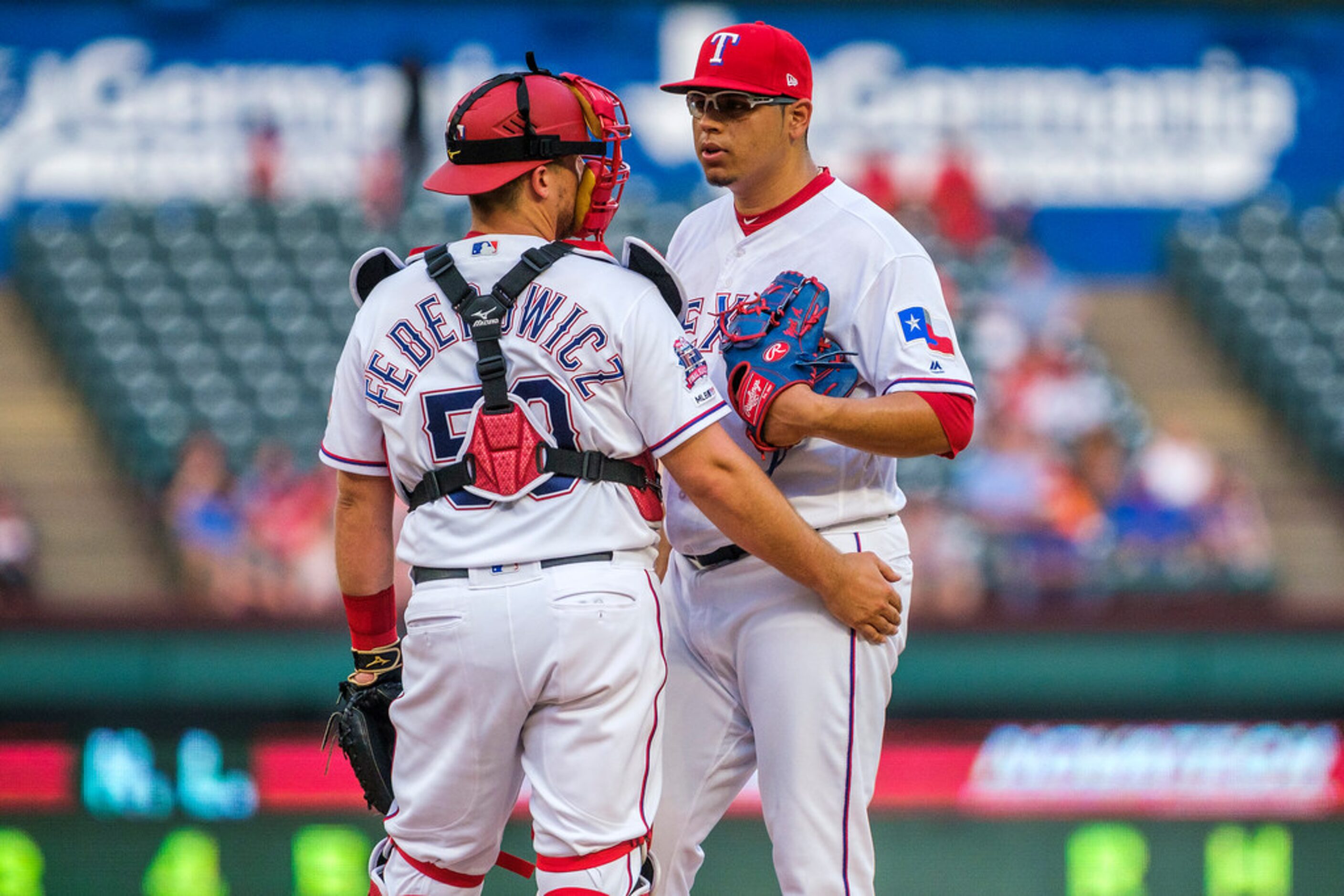 Texas Rangers relief pitcher Ariel Jurado (57) gets a visit from catcher Tim Federowicz (50)...