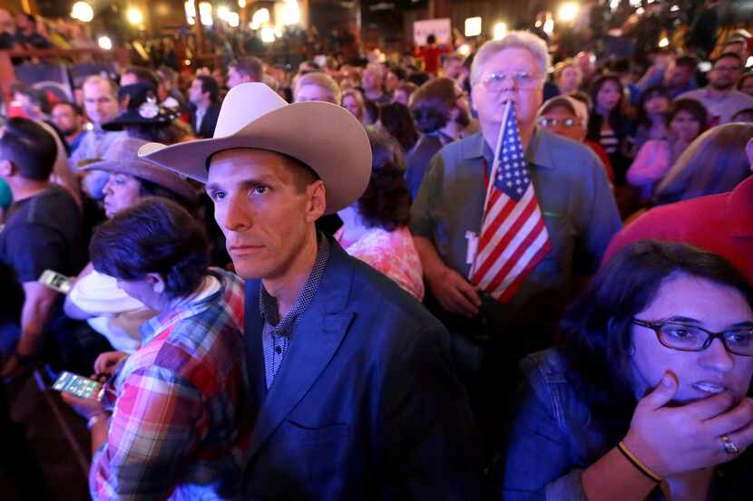 Steven Ness, left, watches as returns are displayed on a monitor as he waits for Republican...