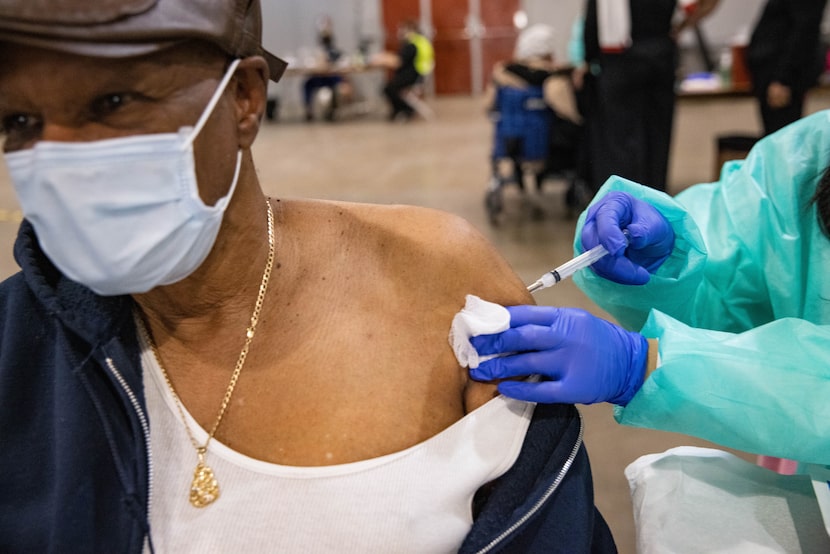 Verely Cooper, 81, of DeSoto looks away as he receives the COVID-19 vaccine at Fair Park in...