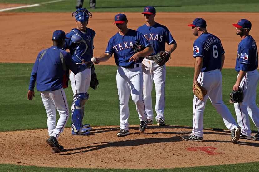 Mar 5, 2014; Surprise, AZ, USA; Texas Rangers pitcher Neal Cotts (56) hands the ball over to...