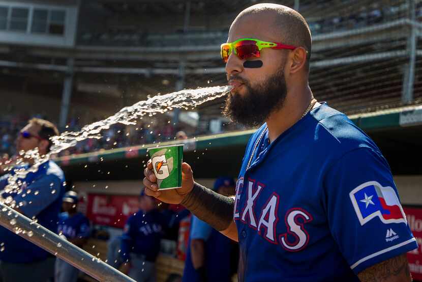 Texas Rangers second baseman Rougned Odor spits out a mouth full of water in the dugout...