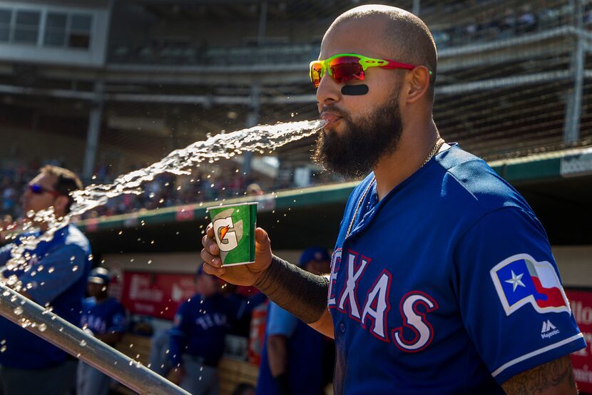 Texas Rangers second baseman Rougned Odor spits out a mouth full of water in the dugout...