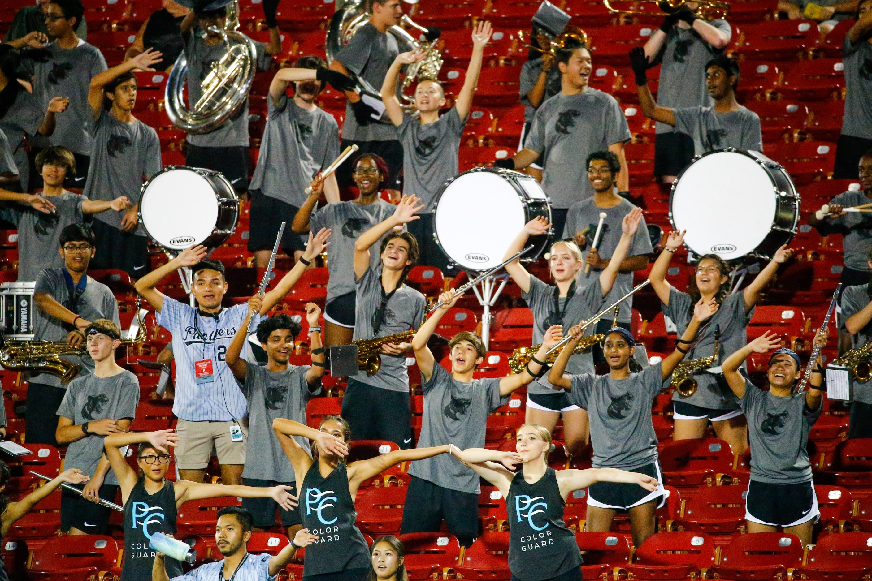 Panther Creek Panthers band members sing and dance along to Emerson Mavericks band playing...