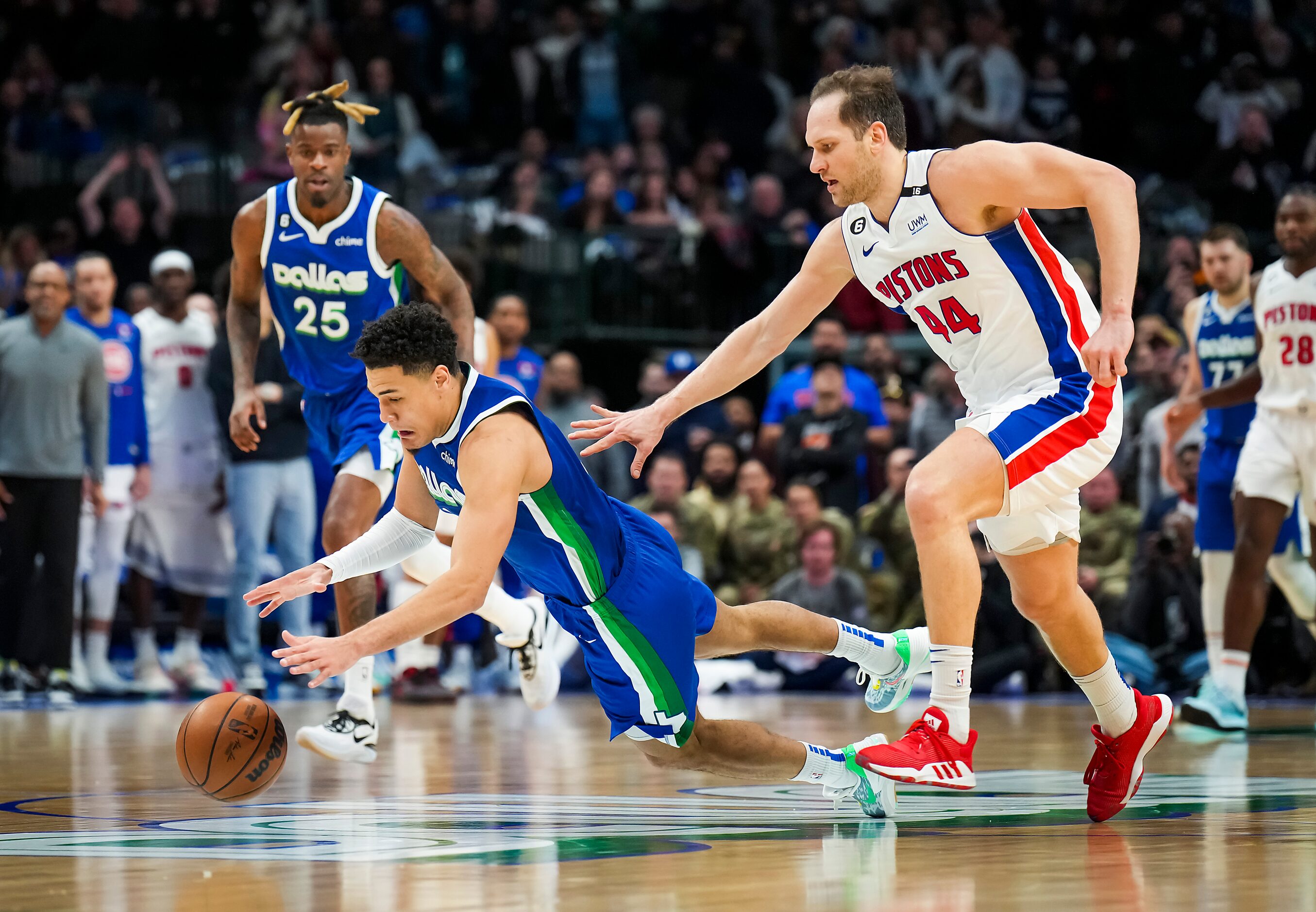 Dallas Mavericks guard Josh Green (8) dives for a loose ball against Detroit Pistons forward...