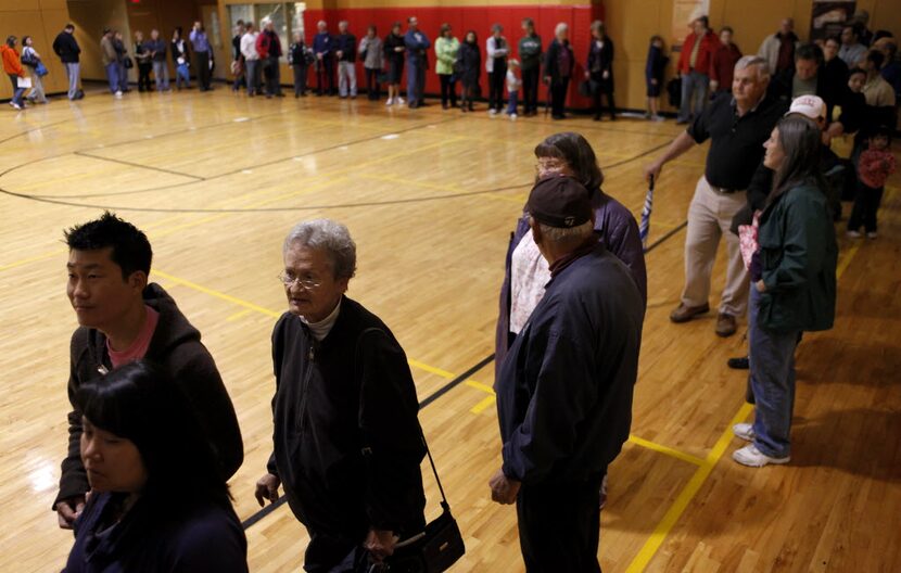 Collin County voters wait to vote in a line which stretched through the lobby and three...