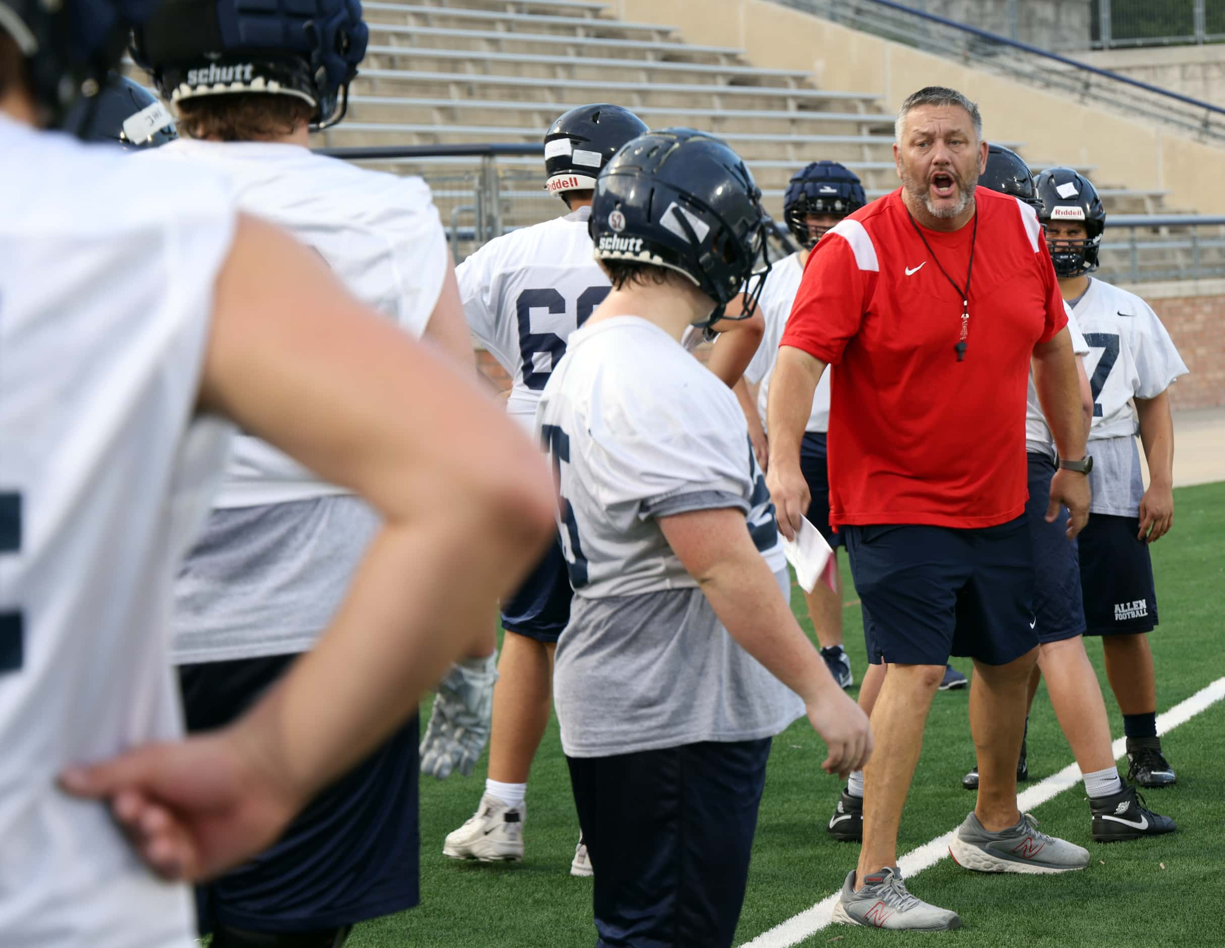 Allen Eagles assistant coach Larry McRae, right, directs offensive line players through a...