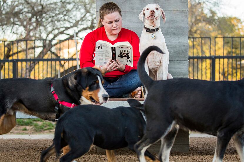  Tracy Cox reads a book as she visits the Johnny Steele Dog Park in Buffalo Bayou Park with...