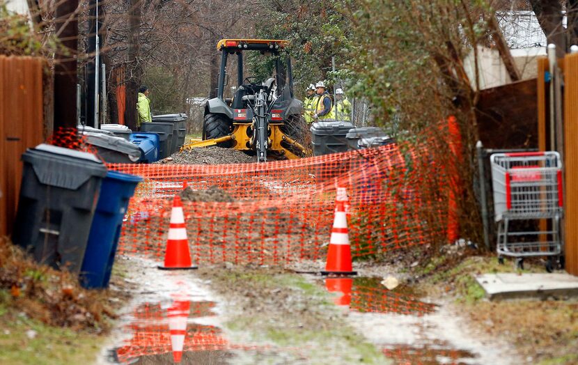 A crew gathers in the alley behind the scene of a Feb. 23 gas explosion that killed...