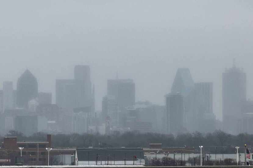 The Dallas skyline less visible from the Dallas Love Field airport as a wave of ice and...