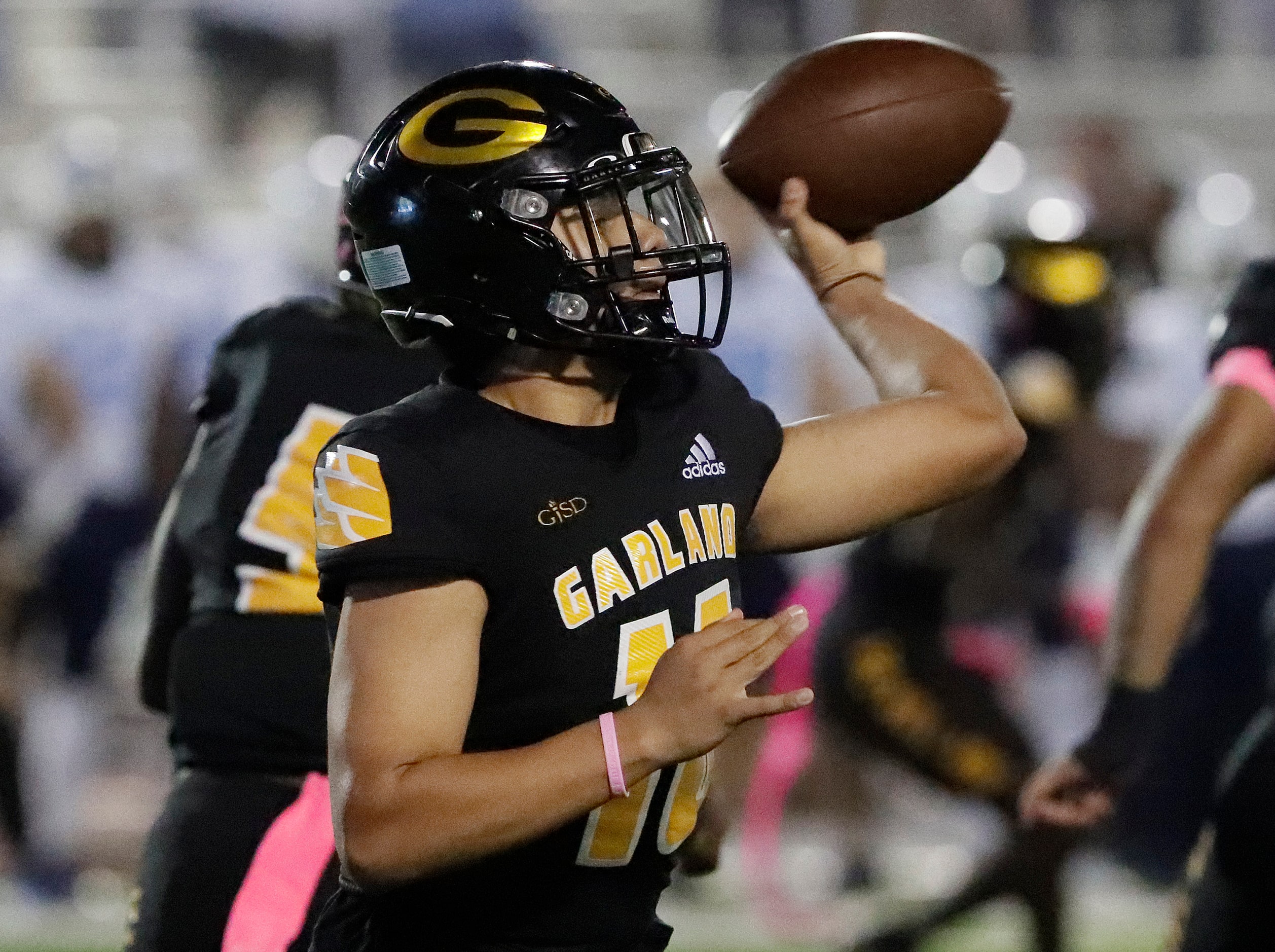 Garland High School quarterback Carlos Mojica (16) throws a pass during the first half as...