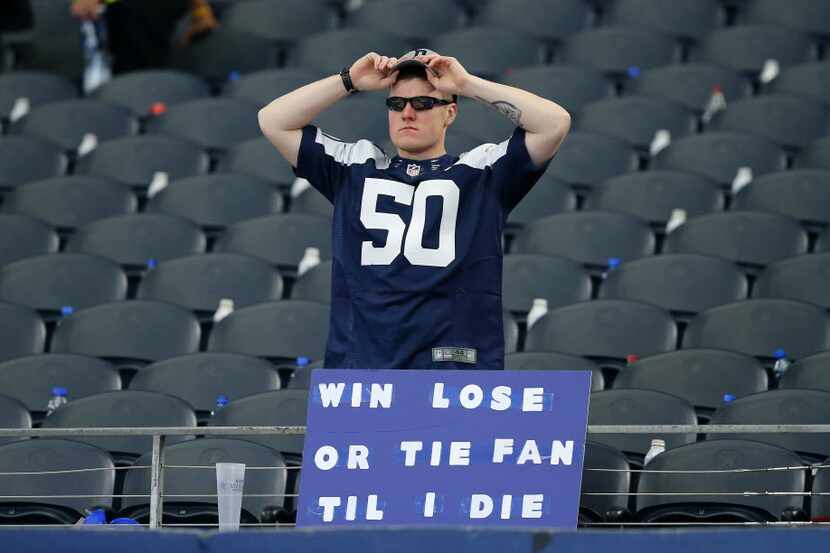 A Dallas Cowboys fan stands around after his team lost their final game of the season to the...