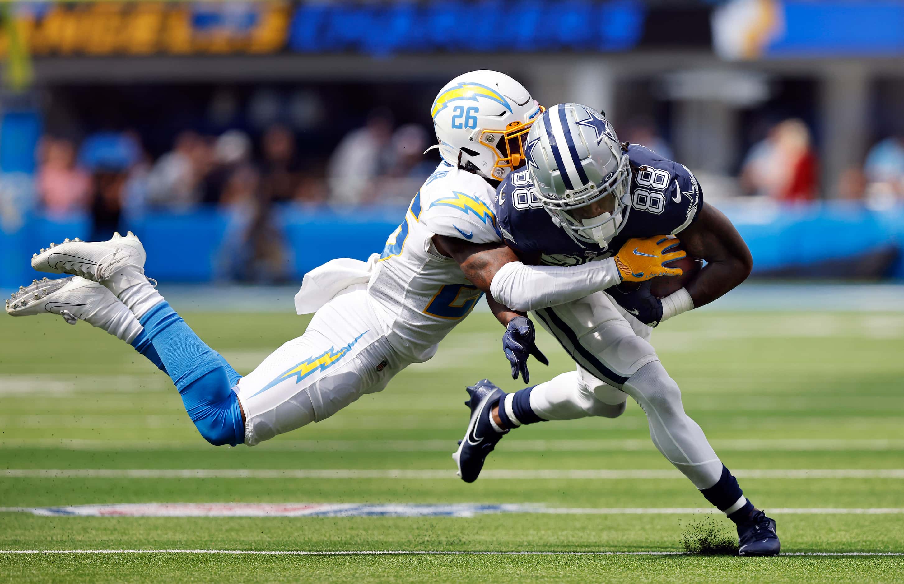 Dallas Cowboys wide receiver CeeDee Lamb (88) is brought down by Los Angeles Chargers...