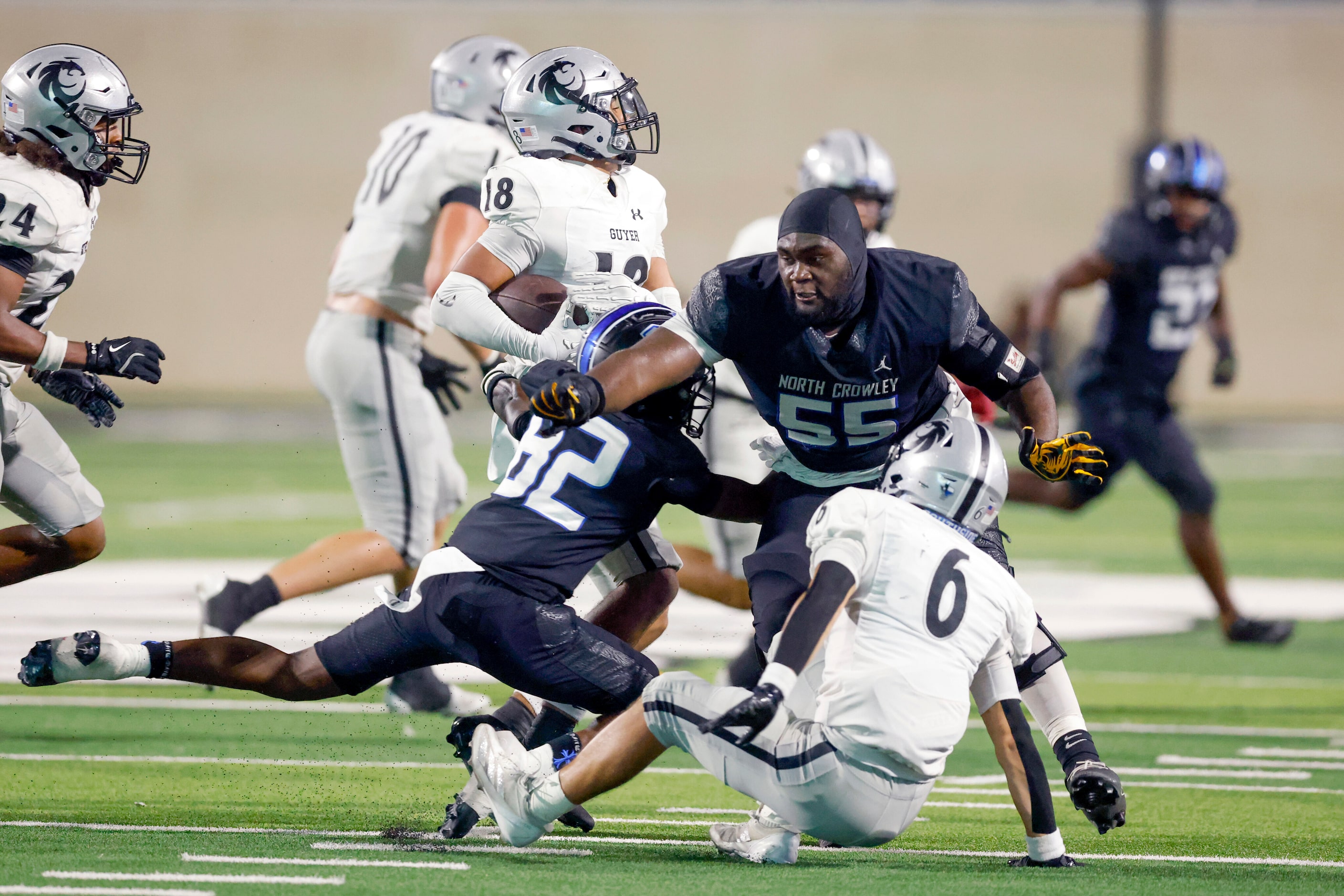 North Crowley offensive lineman Henry Fenuku (55) tries to tackle Denton Guyer defensive...