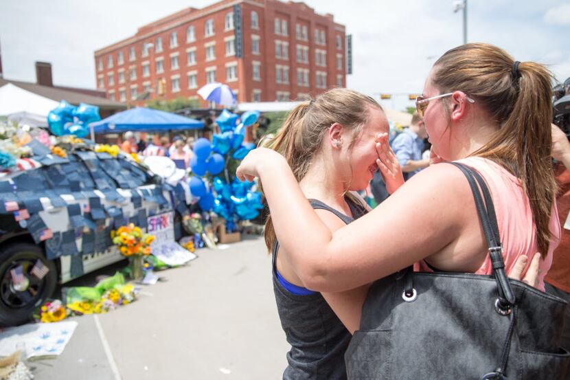 Abbey Wheeler, 14, wipes away tears as her  sister Madison Wheeler, 19, comforts her in...