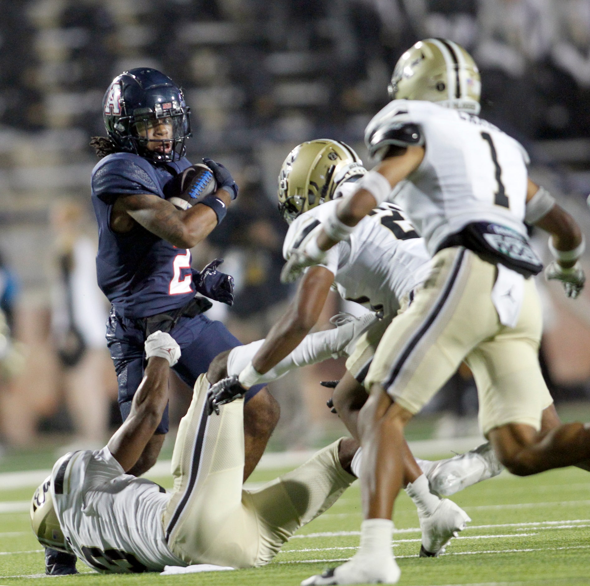 Allen running back Micah Ellis (2), left, spins from the pursuit of Plano East defenders...