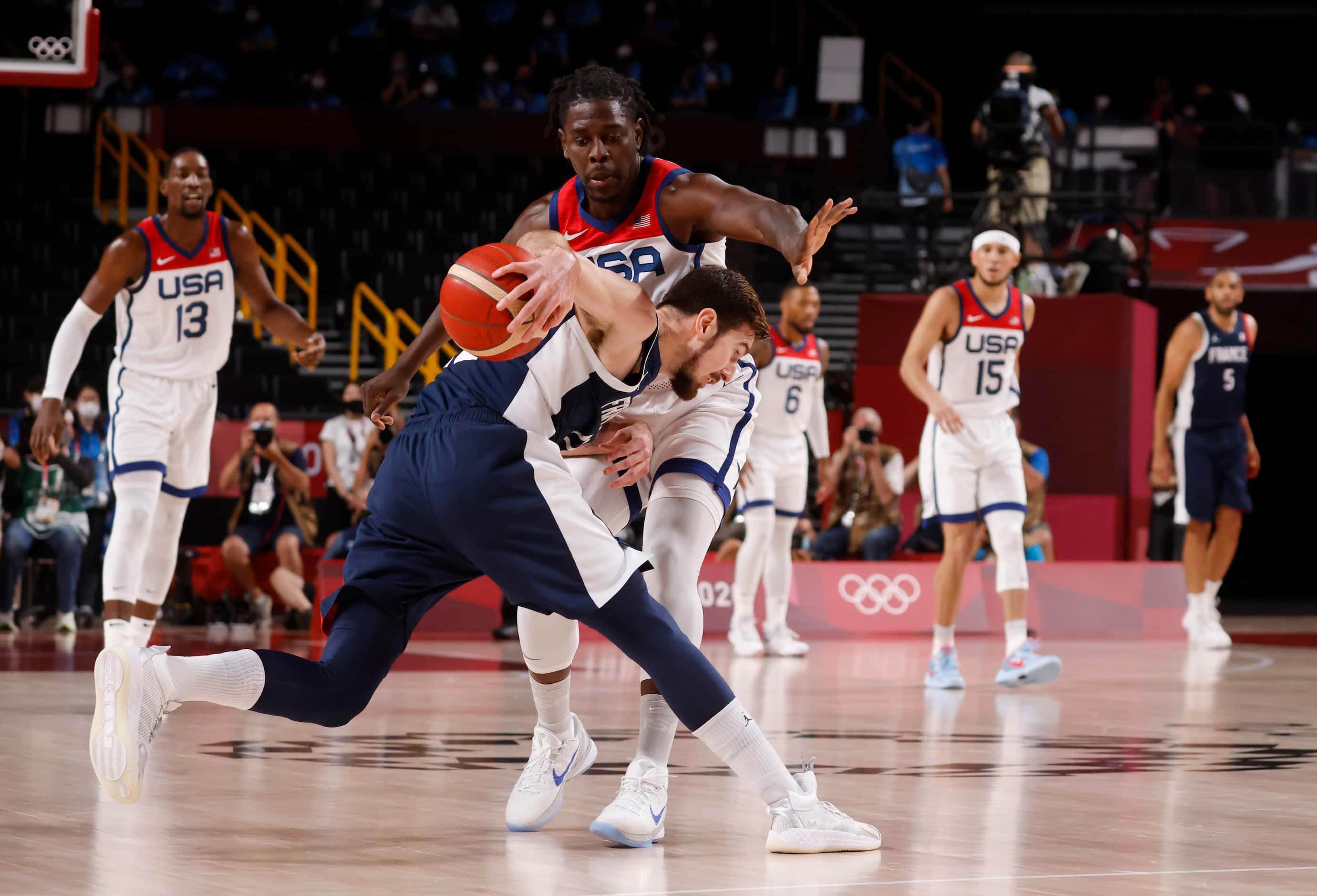USA’s Jrue Holiday (12) defends as France’s Nando de Colo (12) dribbles during the first...