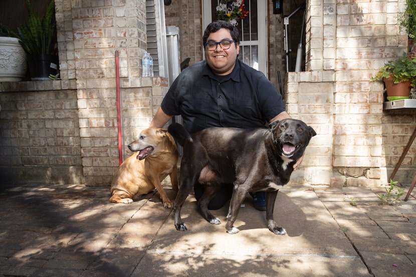 Ruben Florido poses with his dogs Daisy, left, and Missy at his family's home in West Dallas...