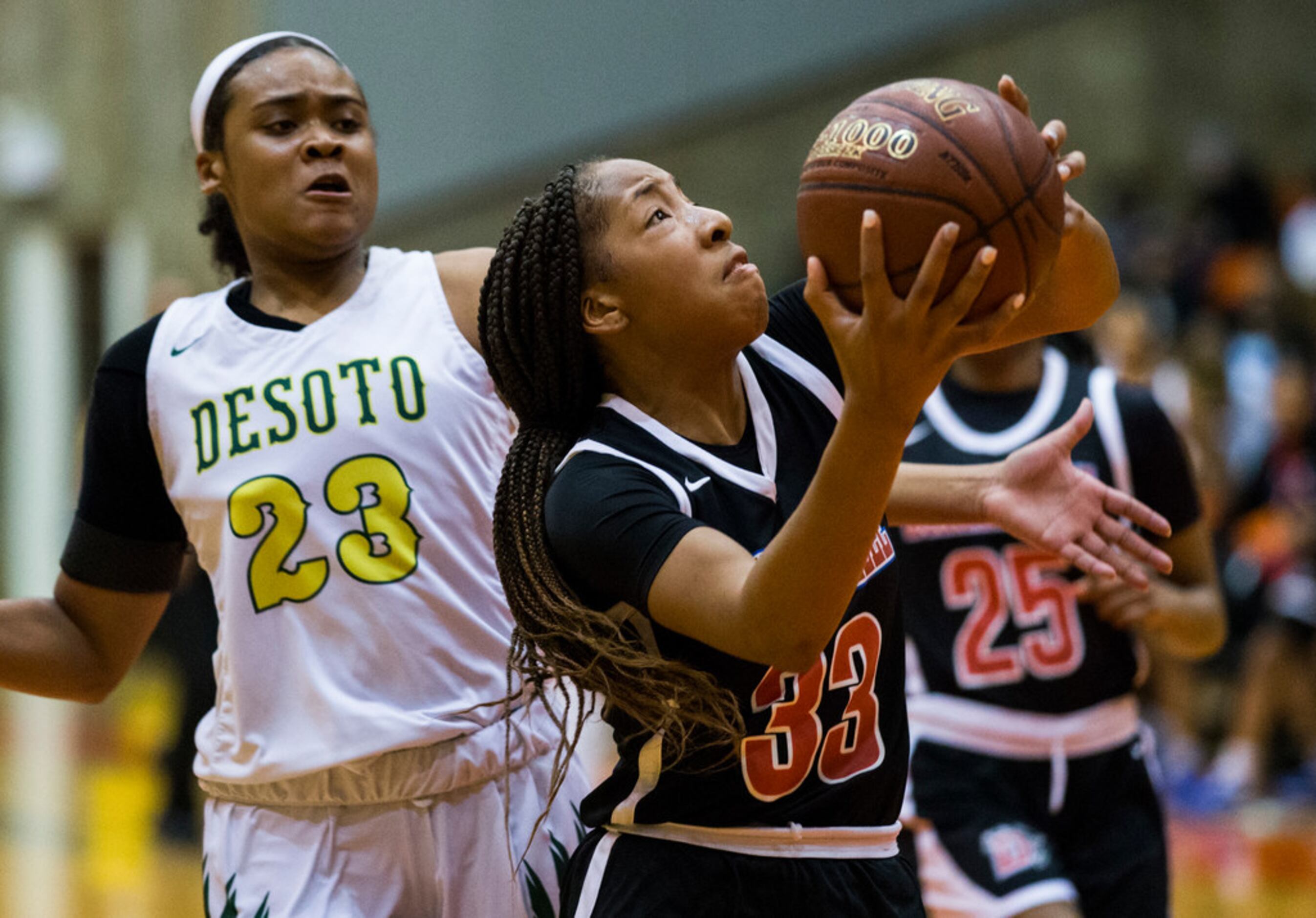 Duncanville's Nyah Wilson (33) goes up for a shot while DeSoto's Kendall Brown (23) defends...