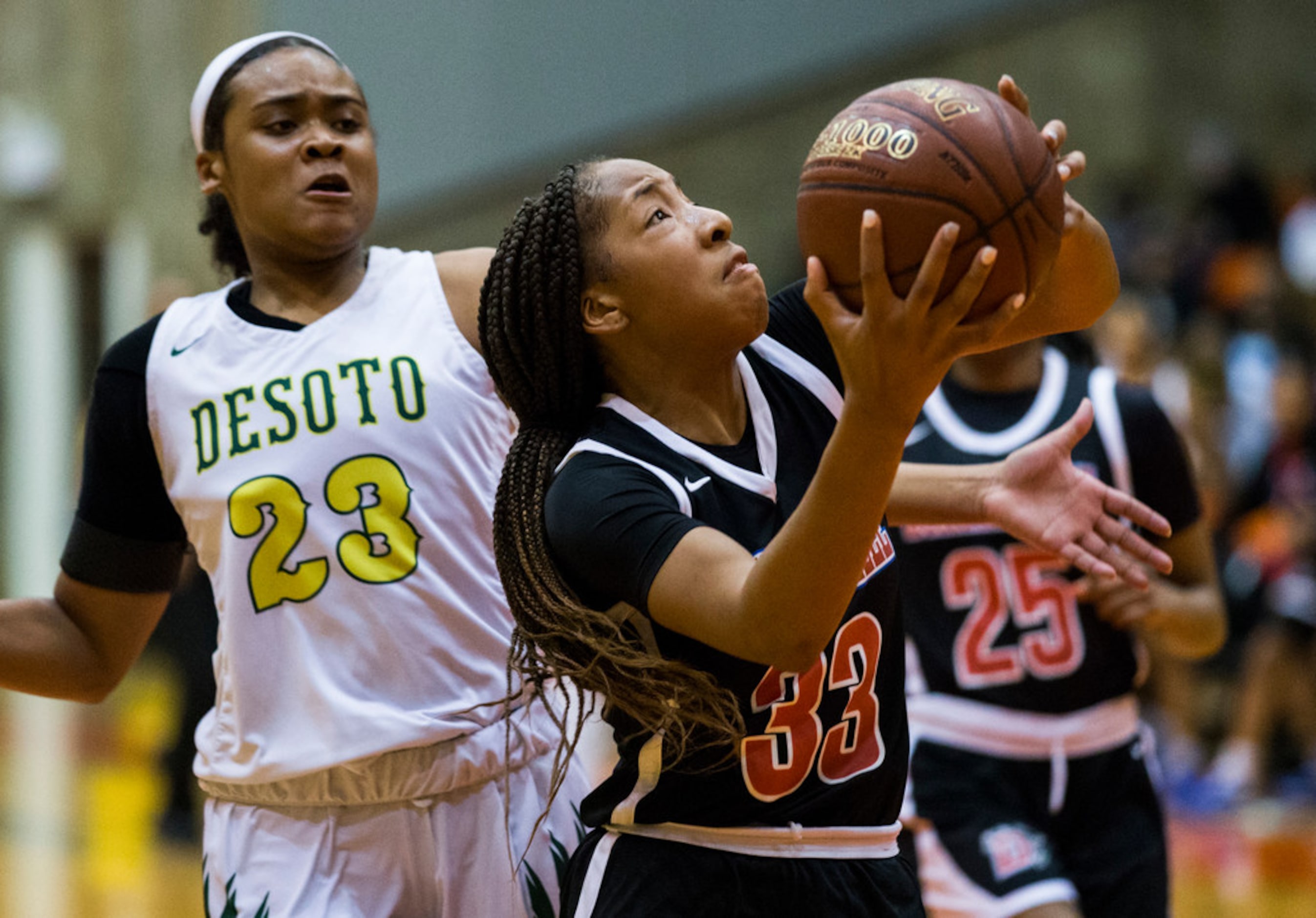 Duncanville's Nyah Wilson (33) goes up for a shot while DeSoto's Kendall Brown (23) defends...