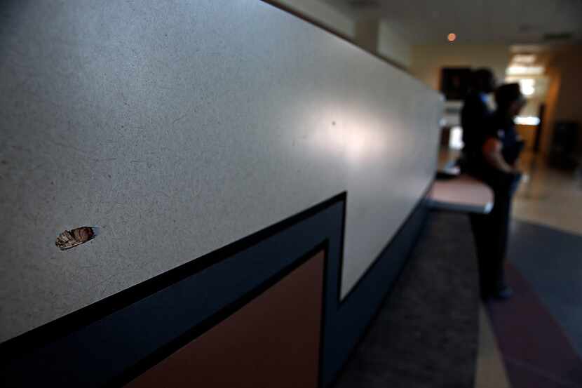 
A bullet hole is seen in the front desk of the Dallas Police Department's Jack Evans Police...
