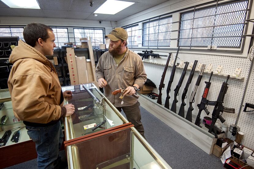 Shane Farren of Ashby Arms, Va., talks with customer Daniel Suter about stock options for...