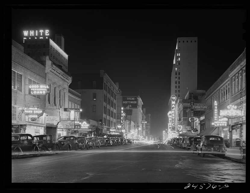Downtown Dallas looking west down Elm Street at night in January 1942. The Majestic Theater,...