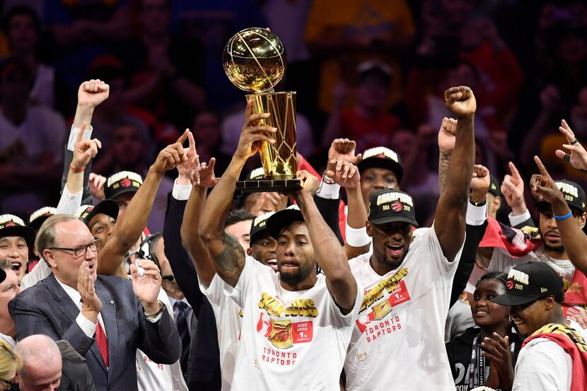 Raptors forward Kawhi Leonard (center) holds the Larry O'Brien Trophy after the Raptors...