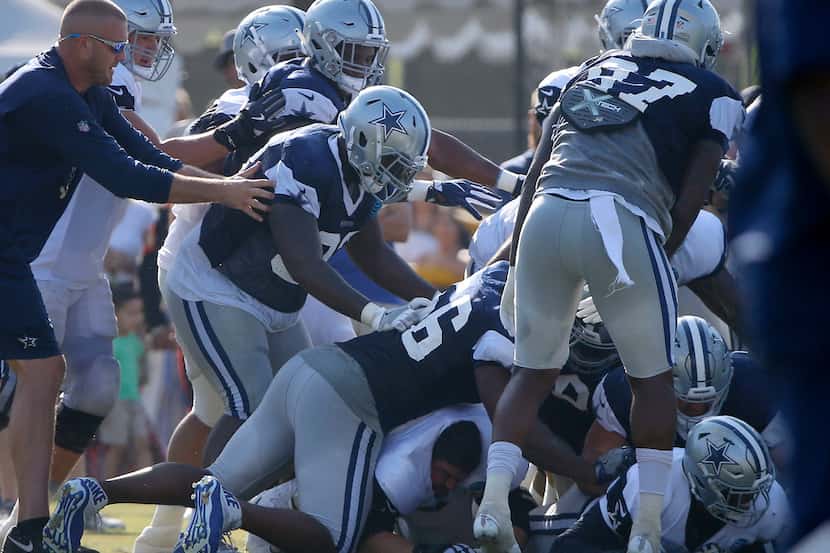 Dallas Cowboys players fight during the afternoon practice at the training camp in Oxnard,...