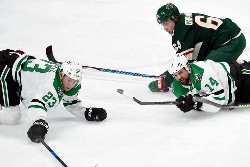 Dallas Stars' Esa Lindell (23), of Finland, knocks the puck away from Minnesota Wild's...