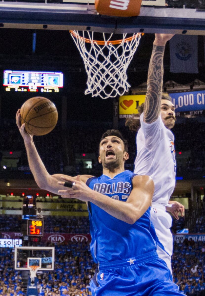 Dallas Mavericks center Zaza Pachulia (27) goes up for a shot under Oklahoma City Thunder...