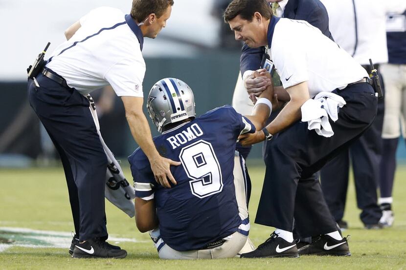 Dallas Cowboys quarterback Tony Romo (9) is tended to by Dallas Cowboys medical staff after...