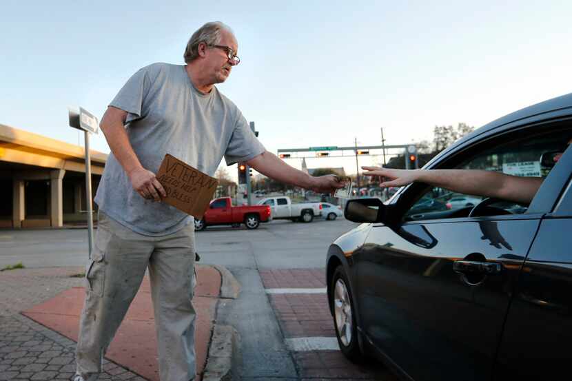 Scott Randall panhandles at the intersection of Walnut Hill Lane and Central Expressway in...
