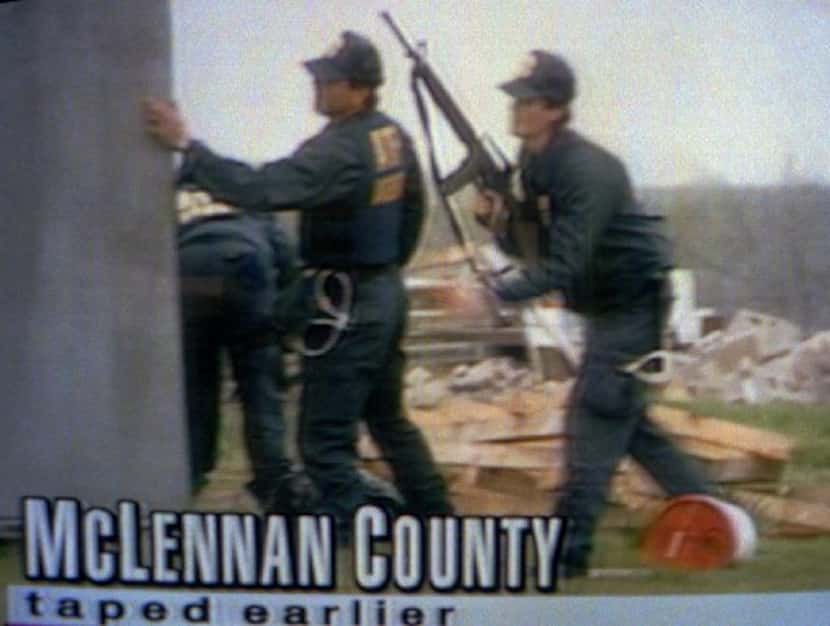 Federal agents prepare to give covering fire to others entering the compound as the raid...