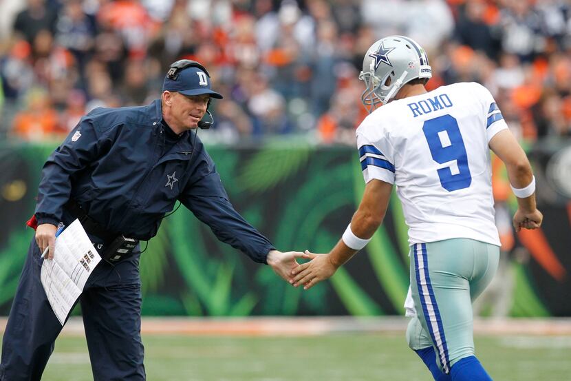Dallas Cowboys head coach Jason Garrett congratulates quarterback Tony Romo (9) after...
