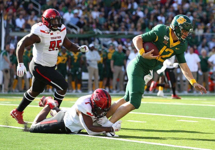 WACO, TEXAS - OCTOBER 12: Jordyn Brooks #1 of the Texas Tech Red Raiders tackles Charlie...